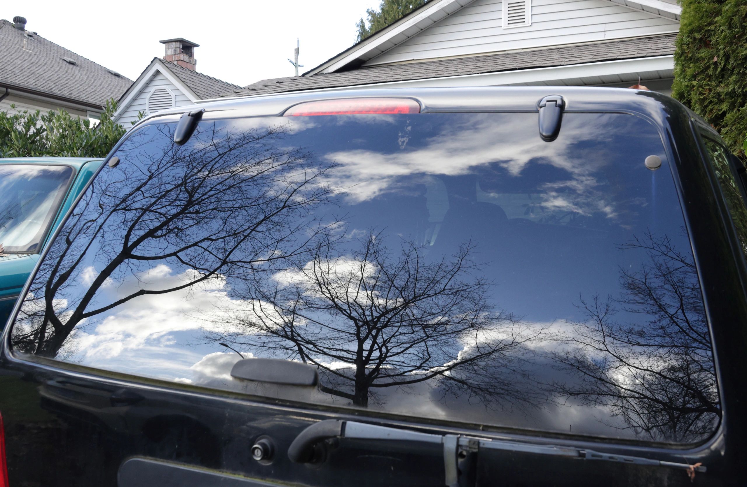 Reflections on a classic car window evoking the Impala cruising experience