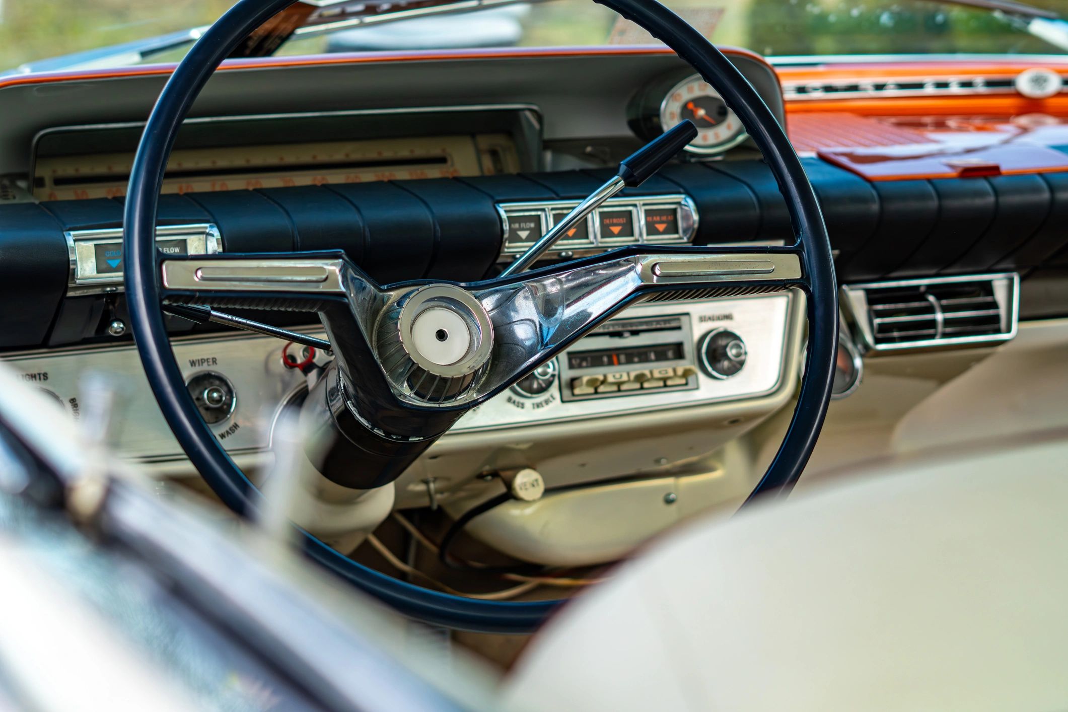Classic car interior with steering wheel and chrome dashboard